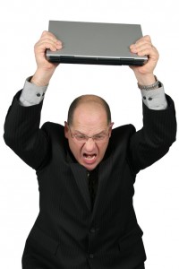 business man with laptop over head - mad